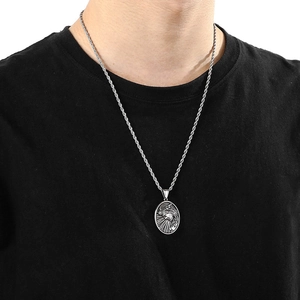 Close-up of stainless steel Jesus pendant with twisted rope chain on a black shirt