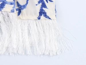 Détail du tissu tie-dye bleu et blanc avec de longues franges blanches sur l'ourlet