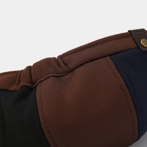 Close-up of tricolor knit fabric with leather strap and golden STYLE metal rivet