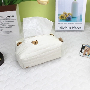 Detail of quilted beige tissue box cover with cute brown bear embroidery and side loop