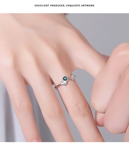 Detail of adjustable silver astronaut ring with green gemstone and star accents