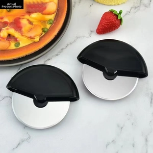 Close-up of stainless steel pizza cutters with ergonomic black handles on marble surface