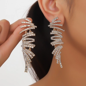 Details von langen goldenen Quastenohrringen mit Strasssteinen am Model für Abendmode