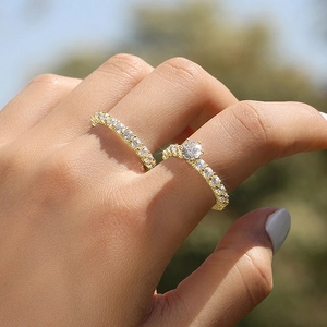 Close-up of sparkling gold engagement ring set with round cubic zirconia on hand