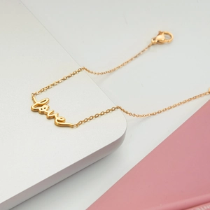 Detailed close-up of 18K gold-plated LOVE letter pendant on a minimalist chain