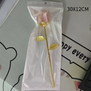 Macro detail of 30x12cm pink crystal resin rose with gold stem in clear gift packaging