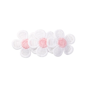 Détail d'une barrette à fleurs brodées avec pétales blancs et cœur rose tendre