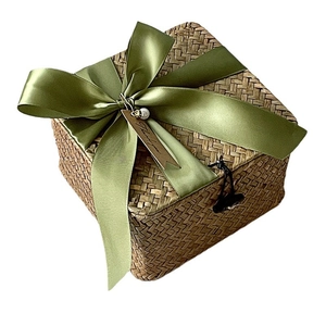 Handwoven straw gift box with olive green ribbon bow and vintage toggle closure