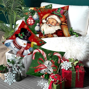 Set of four Christmas pillow covers with Santa and snowman prints on a white sofa