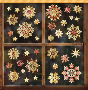 Detail of gold and white snowflake window clings on a glass frame for Xmas decor