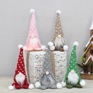 Détail de cinq nains de Noël tricotés aux couleurs douces avec motifs de cœurs et barbes
