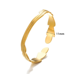 Detail shot of golden open cuff bracelet showing 11mm wide leaf shape with dot relief