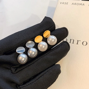 Detailed view of elegant gold white pearl and silver grey pearl stud earrings pair