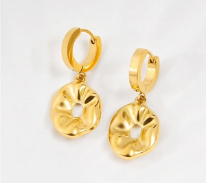Macro detail of gold hoop earrings featuring minimalist wrinkled hollow circular pendants