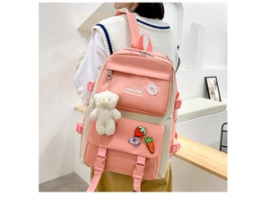 Pink canvas backpack with cute cartoon badges and bear pendant shown on a model