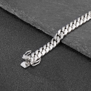 Detail shot of 8mm silver Cuban link chain with box clasp on dark textured background