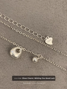 Detailed macro view of S925 sterling silver chain with heart tag and polished pendant
