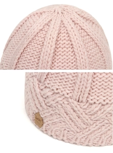 Detail of pink cable knit beanie showing thick wool texture and brown leather label