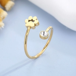 Macro de la bague ouverte dorée avec motif patte de chat et zircon blanc étincelant