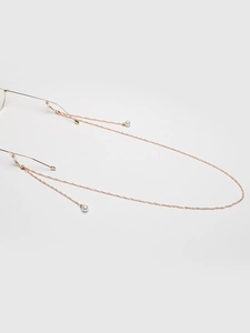 Detail of gold eyewear chain featuring white faux pearls and anti-slip rubber loops