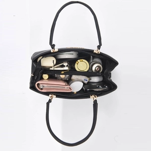 Black pebbled leather tote bag with gold hardware showing large interior capacity