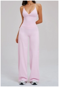 Détail d'un ensemble de yoga rose pâle avec caraco à col en V et pantalon large taille haute