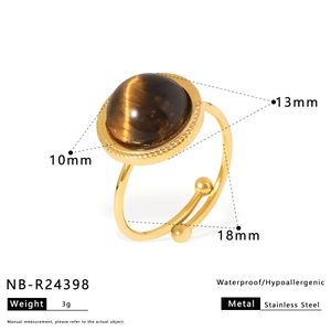 Détail d'une bague vintage en acier inoxydable doré ornée d'un œil de tigre brun