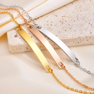 Polished stainless steel bar bracelet in gold, rose gold, and silver colors on silk background
