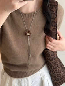 Detail of leopard print heart flower pendant with clear crystal on long silver chain