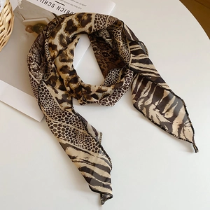 Detailed flat lay of leopard print silk scarf on a magazine with high-end texture