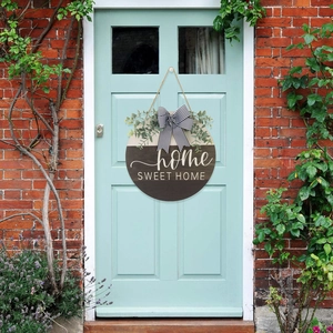 Wooden Home Sweet Home door sign with striped bow and eucalyptus leaves on a blue door