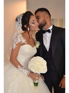 Gros plan sur une robe de mariée ivoire avec des appliques en dentelle et broderies pailletées