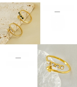 Detail of gold-plated stainless steel heart ring featuring white and green zircon stones