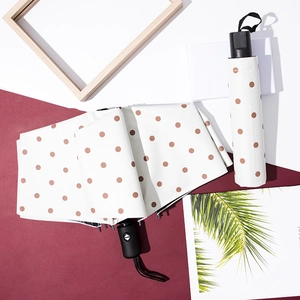 White polka dot folding umbrella with UV protection and minimalist wood frame styling