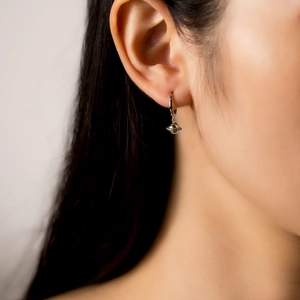 Macro shot of S925 silver ice cream earrings featuring a gold Saturn design and crystals