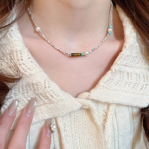 Detail of beaded necklace with tiger eye stone and white pearls on silver chain