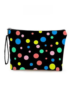 Détail du motif à pois colorés sur la trousse noire zippée avec dragonne pour le maquillage