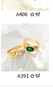 Macro shot of gold-plated rings with clear and green zircon stones on white fabric