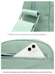 Detail of mint green Oxford bag featuring durable metal buckle and secure back zipper pocket