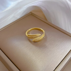 Elegant gold feather open ring with zircon micro-paving on a luxury silk background