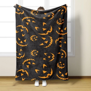Close-up of soft flannel Halloween blanket featuring orange pumpkin face prints
