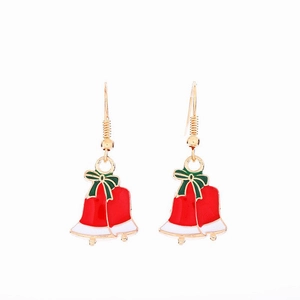Detail of Christmas bell earrings with red bow and colorful enamel finish on white background