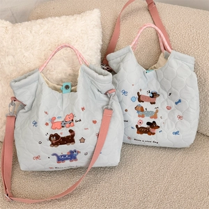 Detailed embroidery of cat and dog patterns on light blue quilted crossbody bag