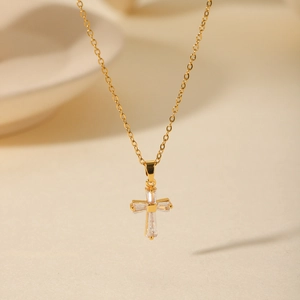 Macro shot of 18K gold plated cross pendant with sparkling zircons on a delicate chain