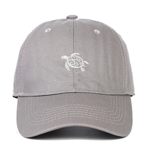 Close-up of detailed white sea turtle embroidery on a gray cotton baseball cap
