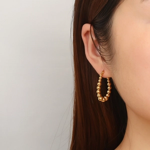 Fashionable 18K gold plated stainless steel beaded hoop earrings for women on model