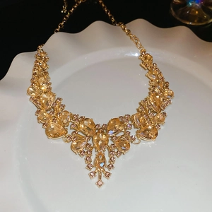 Detailed view of champagne crystal teardrop necklace on a white decorative plate
