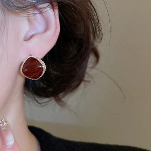 Close-up of red zircon stud earrings with gold plating on model for elegant styling