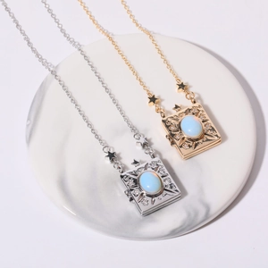 Detailed view of vintage gold and silver book locket necklaces with celestial engravings