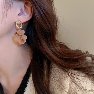 Close-up of elegant gold and brown petal earrings worn by a model in French vintage style